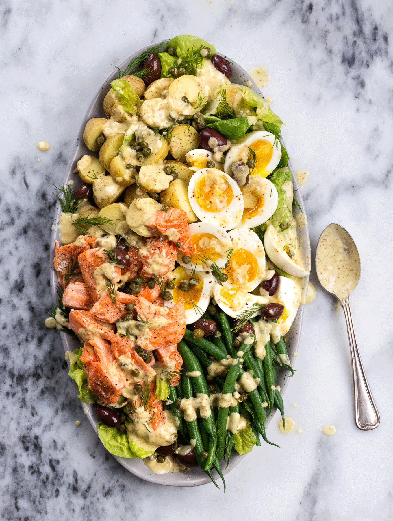 Salmon Nicoise Salad with dressing drizzled on top